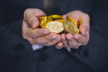 Close-up of businessman's hands full of bitcoin sign of coins - cryptocurrency financial trade wealth and business investment and blockchain technology