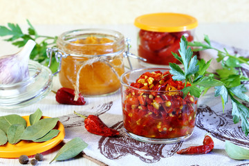 Fototapeta na wymiar Home canning. Billets from hot pepper with spices in jars.