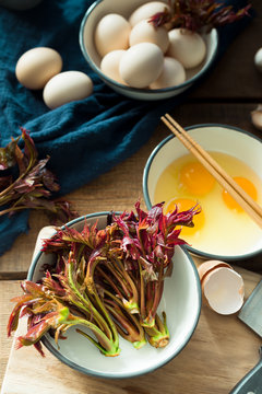 toona sinensis and eggs on wooden table