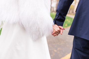 Happy couple holds hands of each other. Wedding day. Concept of union, support and future. 