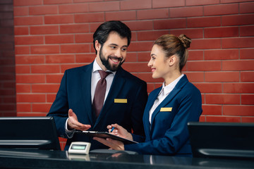 smiling hotel receptionists working together at counter