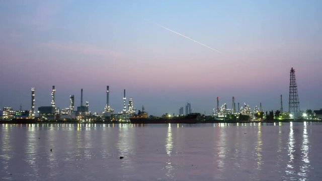 oil refinery plant and shipping with water reflection light, time lapse night to day 