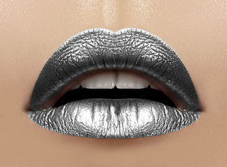 Beautiful closeup with female plump lips with silver color makeup. Christmas celebrate make-up, glitter sparkles on lip