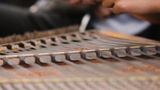 Musician hands playing dulcimer instrument at rehearsal, traditional folk music