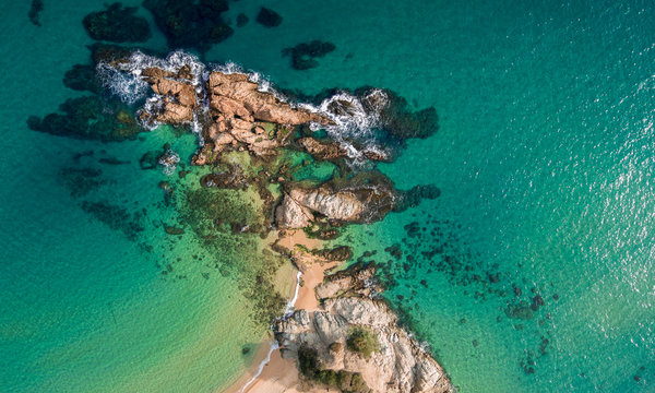 Aerial views of the rocks in the sea on a sunny day.