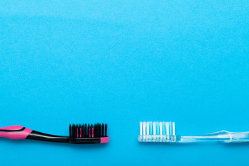 Colorful plastic toothbrushes on blue background. Empty copy space for text.