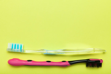 Toothbrushes on yellow background, copy space.