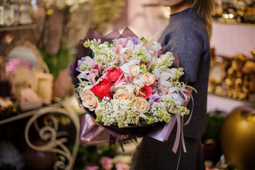 Woman holding a beautiful big bouquet of roses and other flowers