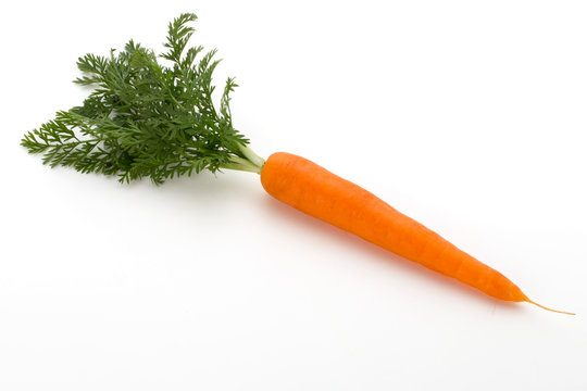 Carrot vegetable with leaves on the wooden background.