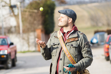 Happy dogwalker throwing up a tennisball