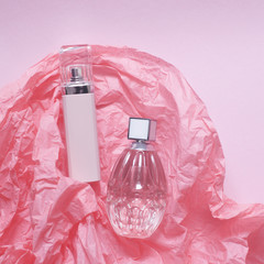 Women's perfumes in the bottles on the pink background