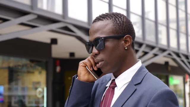 Success, Business- Handsome black african manager talking by phone in the city 