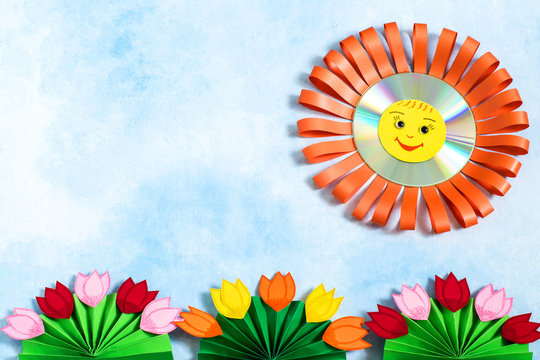 Children's crafts made of paper and CD. Sun and flowers