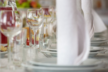 Beautiful table setting with crockery and flowers for a party, wedding reception or other festive event. Glassware and cutlery for catered event dinner
