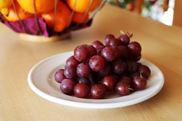 The red grapes on the white plate
