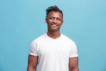 The happy afro-american business man standing and smiling against blue background.