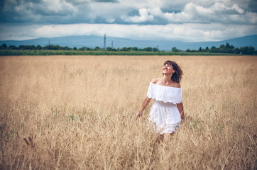 Naklejka na ściany i meble Young girl on wheat field