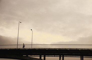 Silhouette person on the bridge with street lanterns