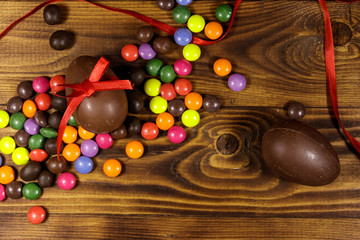 Easter composition with chocolate eggs on wooden background