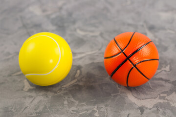Two new soft rubber tennis and basketball balls on old worn cement