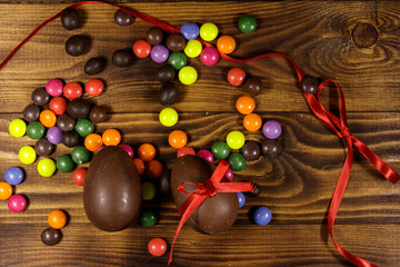 Easter composition with chocolate eggs on wooden background