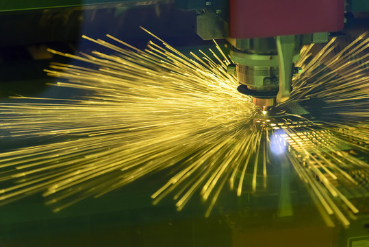 The fiber laser cutting the sheet metal plate with the sparking light.