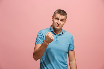 Beautiful male half-length portrait isolated on pink studio backgroud. The young emotional surprised man