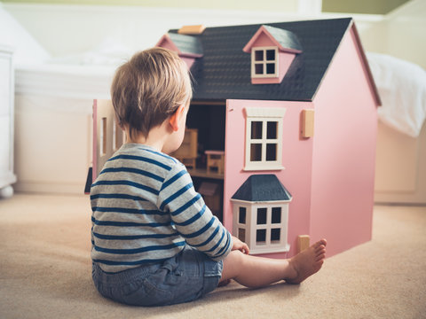 Little boy playing with doll house