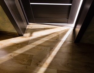 Rays of light from the door in a dark room