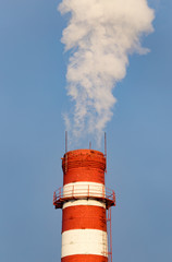 smoke from a pipe in the factory against a blue sky