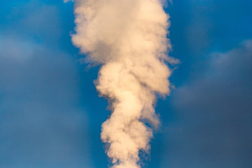 smoke from a pipe in the factory against a blue sky