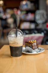 ice coffee take away and cake on wooden background