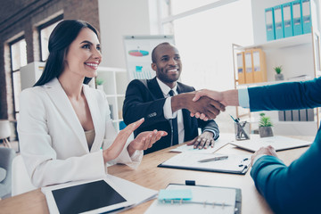Fototapeta premium Two successful executive businesspeople celebrate completed deal about their business with lawyer, sitting in work place, station, wearing suits, men shaking hands, woman applaud to them