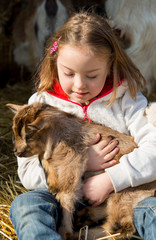 Down syndrome girl playing with baby goat