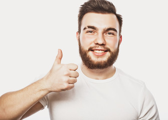 Portrait of a cheerful young bearded man showing okay gesture isolated on the white background