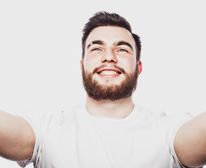 Obraz premium Lifestyle and people concept: Closeup portrait of a happy young man smiling on white background