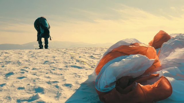 Paraglider flies in the sky on a sunny winter day