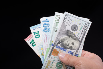 Hand holding American dollar  isolated on black background