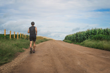 Obraz premium Young man running in the morning. Healthy lifestyle concept. Runner running on road.