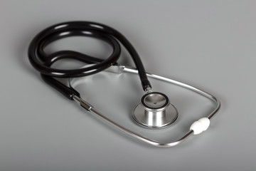 Medical diagnostic tool, stethoscope on gray