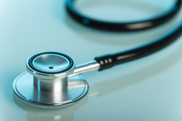 Medical diagnostic tool, phonendoscope on blue. Close-up
