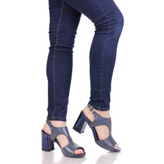 Female legs in jeans and in blue sandals shoes