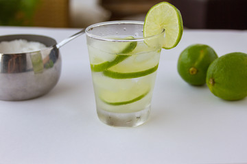 Summer drink -  Brazilian caipirinha, sugar bowl, limes . White background. Selective focus