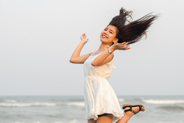 Fototapeta na wymiar Happy woman jumping on the beach, lifestyle concept. Warm light.