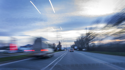 Fototapeta na wymiar urban night landscape on a road with smashed high-speed cars. blurry effect of vehicle speed.