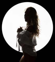 silhouette of a sexy woman on a white circle. Shadows on beautiful body of sexy elegant woman.