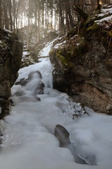 Frozen stream with sunbeams and smooth water