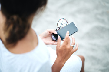 Woman using smartphone on the beach