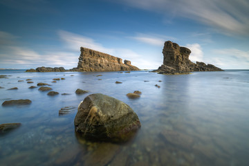 Sea sunrise, near the ship rocks