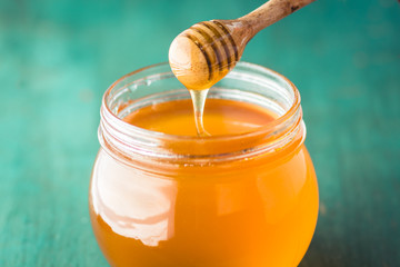 Honey in a glass bottle On blue wood in low light 